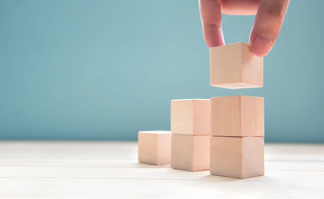 Wooden blocks stacked into steps representing a structured business process