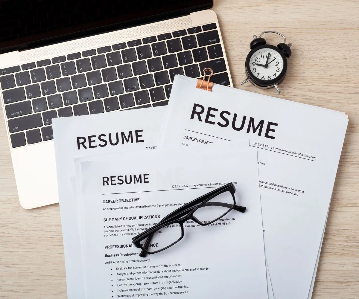 Resume, laptop and phone on a desk representing HR and recruitment consultancy services